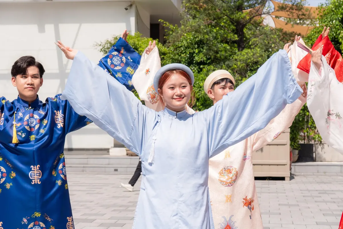若者たちが太陽の下で色鮮やかな伝統的な衣装を着てダンスをしています。