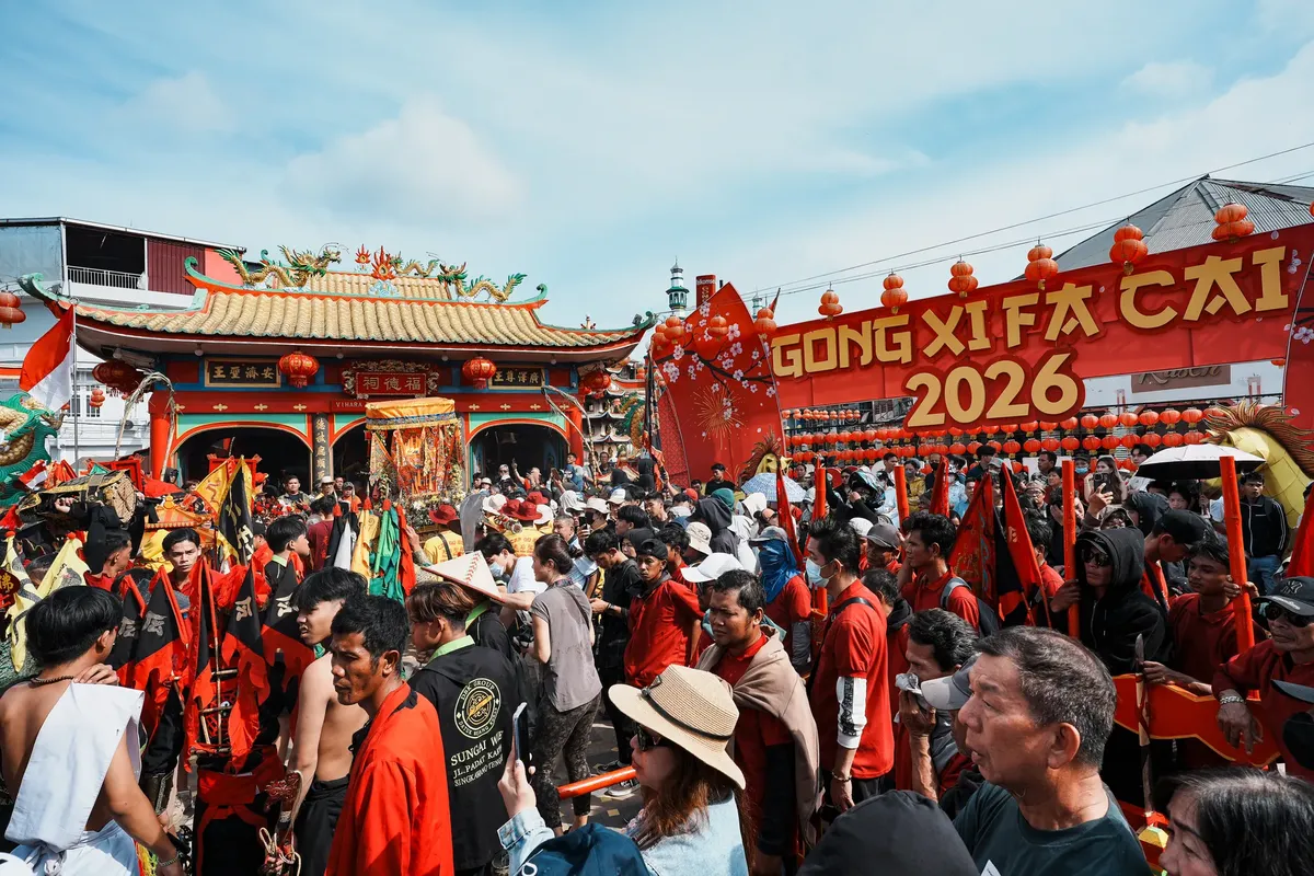 インドネシアのシンガワングに位置する寺での華やかな春節祭りの祝祭行事、にぎやかな人々と祝祭的な飾り付けが見られる。