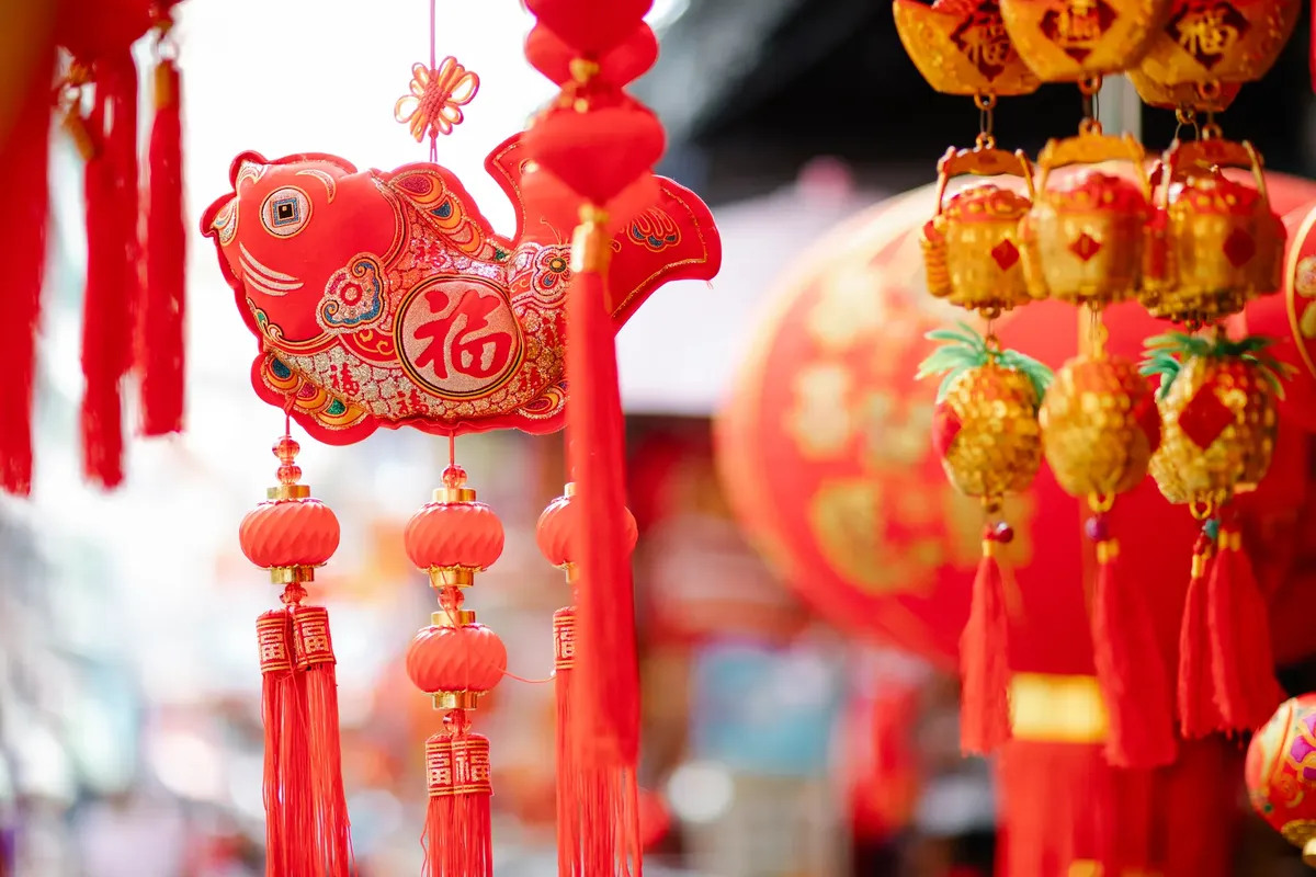 Colorful traditional Chinese lanterns hanging with fish shaped figures hanging on street for New Year