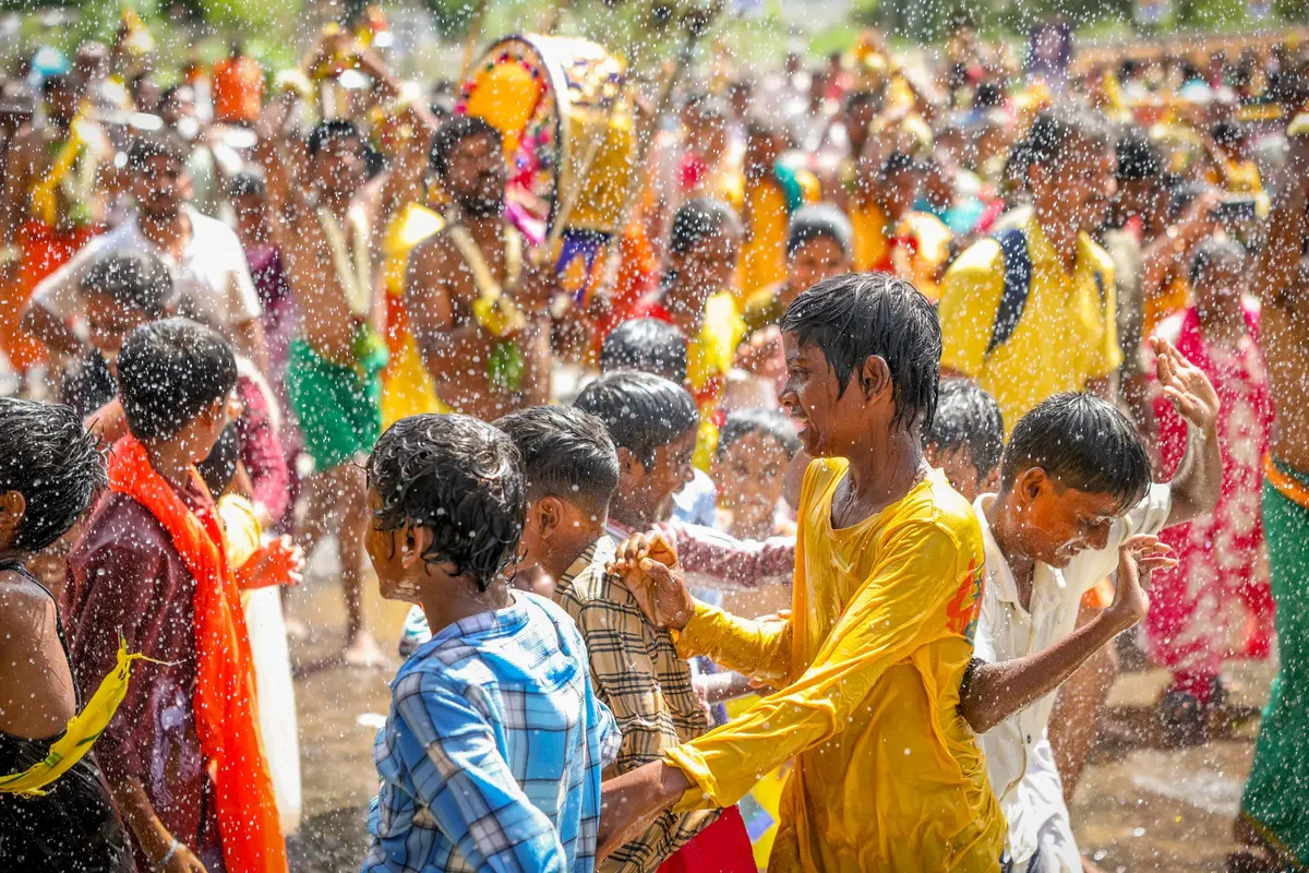 A lively festival scene with children playing joyfully amidst splashing water, capturing the essence of cultural celebration.