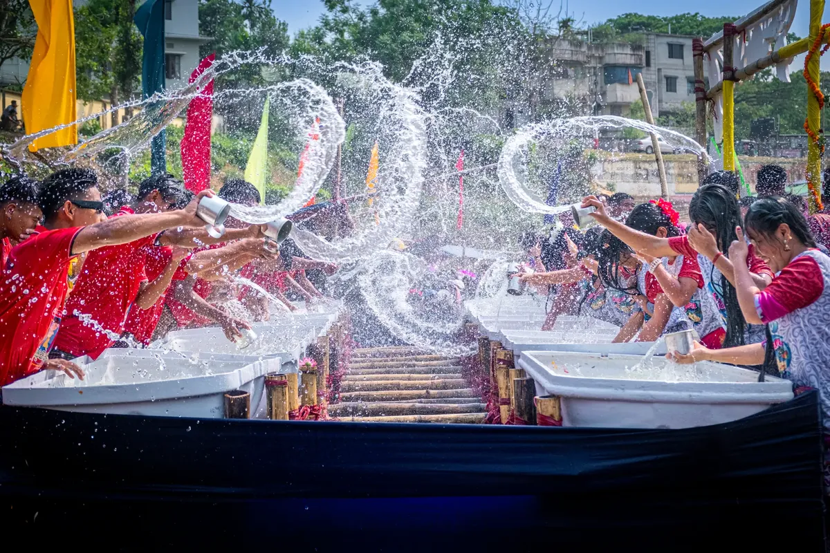 Joyful water festival event with people splashing water, celebrating a cultural tradition in Bangladesh.