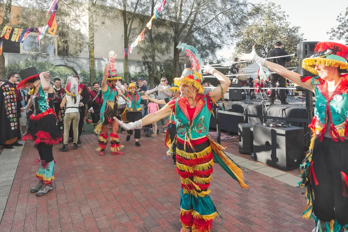 Vibrant street parade with dancers in traditional colorful costumes celebrating outdoors.